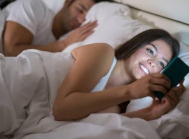 Woman_Sleeping_With_Husband_Using_Phonee